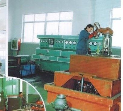 Operator testing a valve on a hydraulic valve test bench at a customer's works